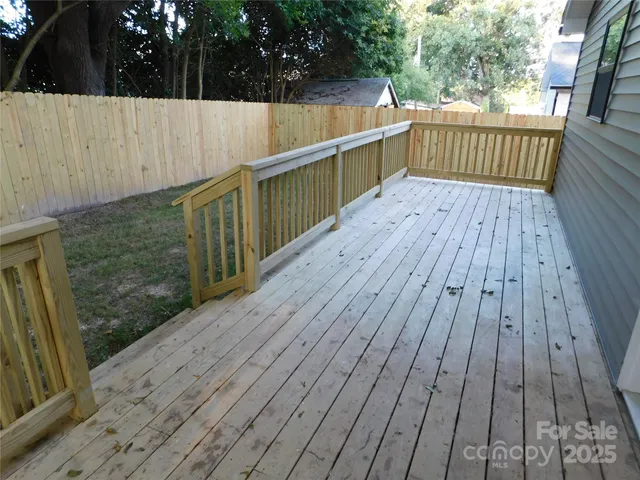 a backyard of a house with wooden fence and deck