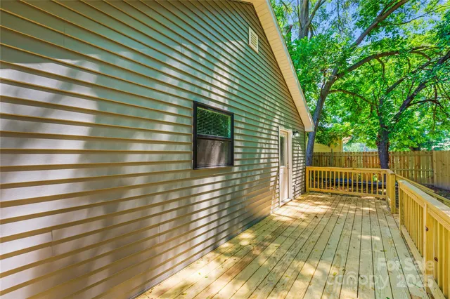 a view of backyard with small cabin and wooden fence