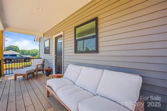 a balcony with wooden floor and outdoor seating