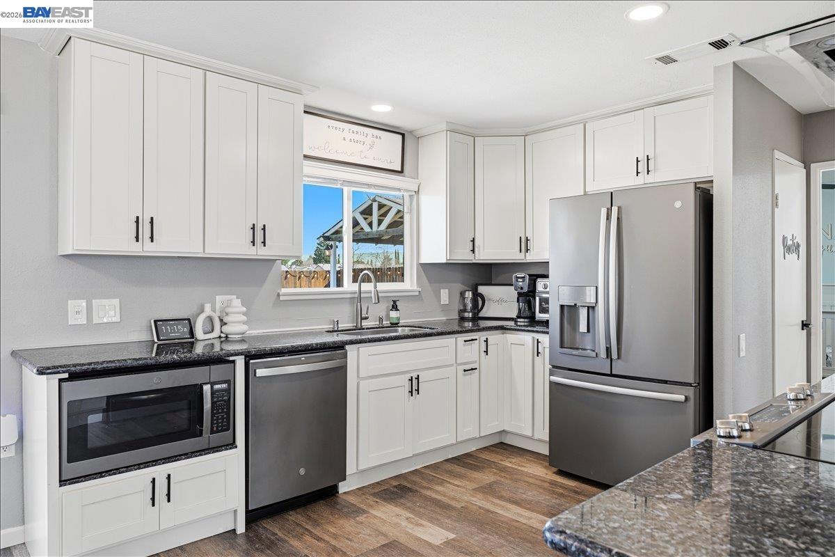 1279 Marigold Road Livermore, CA 94551 - Photo 10 of 53 a kitchen with granite countertop a refrigerator sink and white cabinets