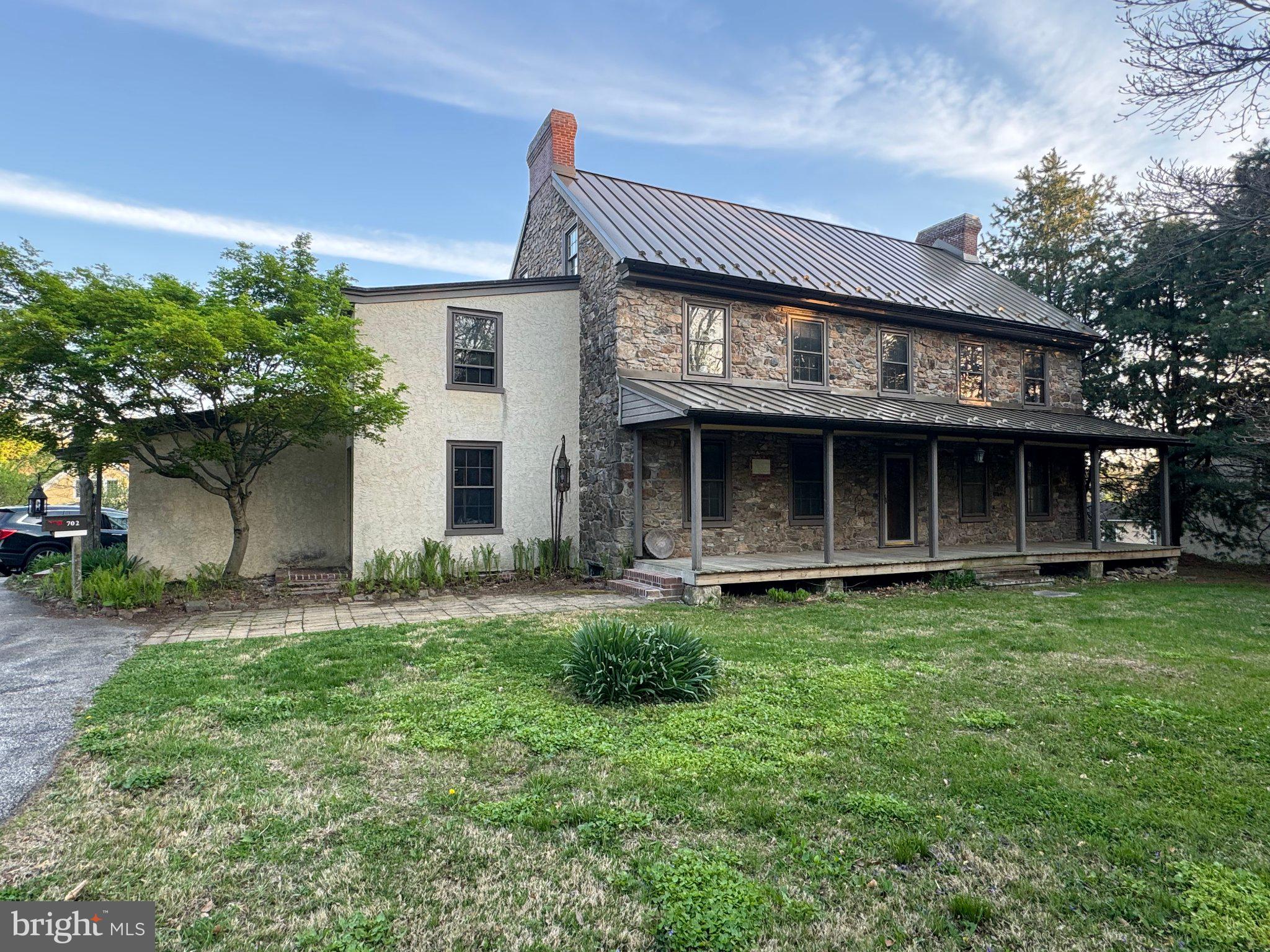 Charming stone home with lush greenery.