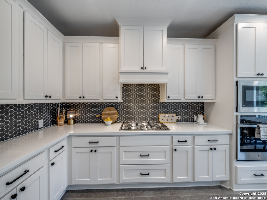 25902 Madison Ranch San Antonio, TX 78255 - Photo 15 of 36 a kitchen with white cabinets and sink
