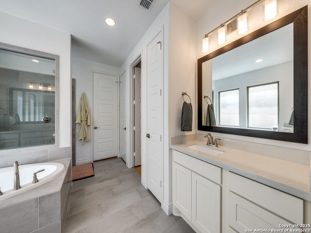 25902 Madison Ranch San Antonio, TX 78255 - Photo 19 of 36 a spacious bathroom with a double vanity sink a mirror and a bathtub