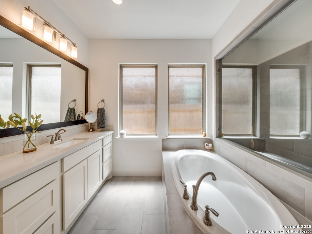 25902 Madison Ranch San Antonio, TX 78255 - Photo 20 of 36 a en suite bathroom with a granite countertop tub and a sink
