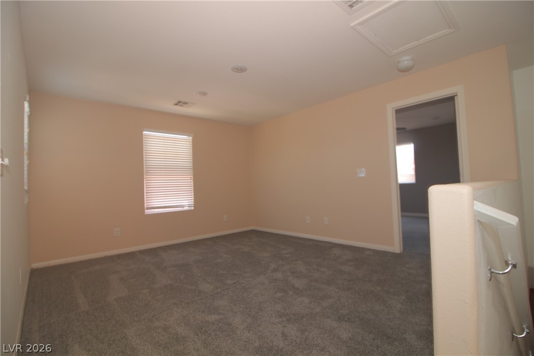 9289 Valley Ranch Avenue Las Vegas, NV 89178 - Photo 15 of 29 A well-lit loft space featuring plush carpet and a window with blinds, offering flexible living.