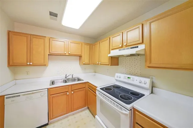 a kitchen with cabinets window and appliances