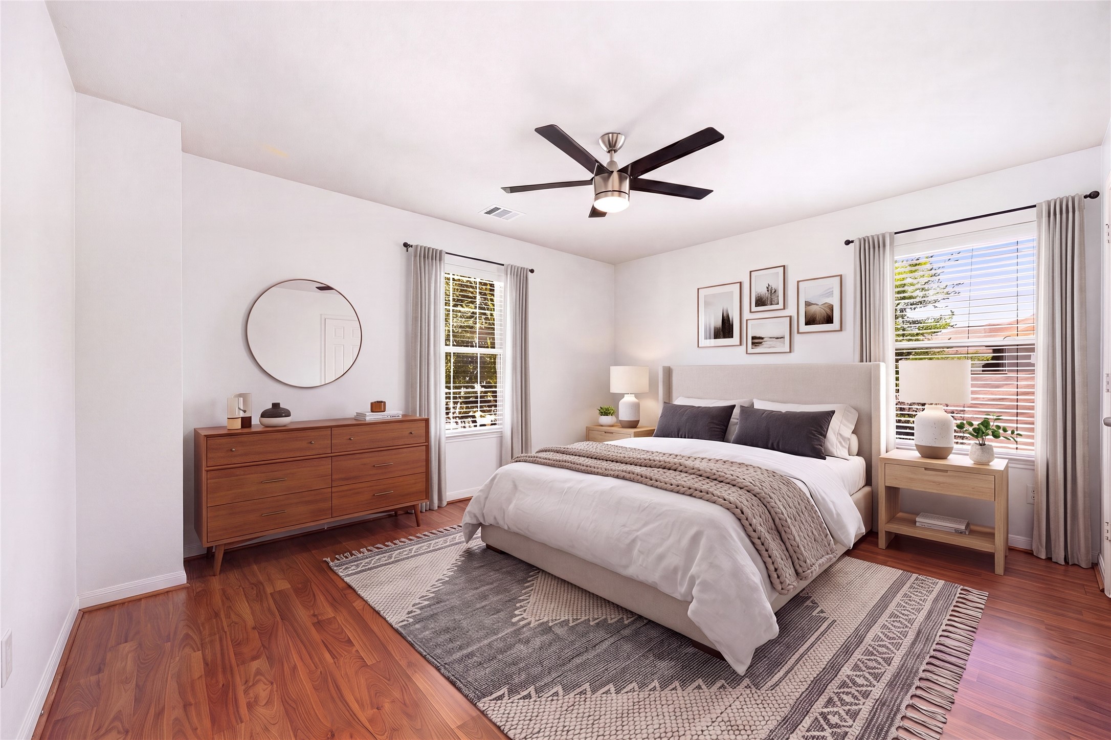 13407 Spring Line Court Houston, TX 77086 - Photo 20 of 29 This spacious secondary bedroom offers a comfortable and inviting retreat with crisp neutral walls and rich hardwood-style flooring. Double-aspect windows flood the space with natural light from two sides, while a modern central ceiling fan keeps the room cool and well-ventilated.