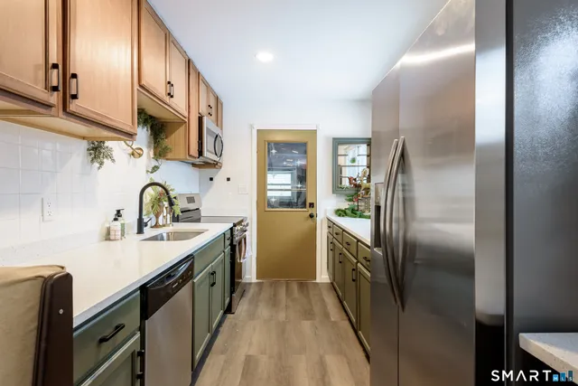 a kitchen with stainless steel appliances granite countertop a refrigerator a sink and dishwasher