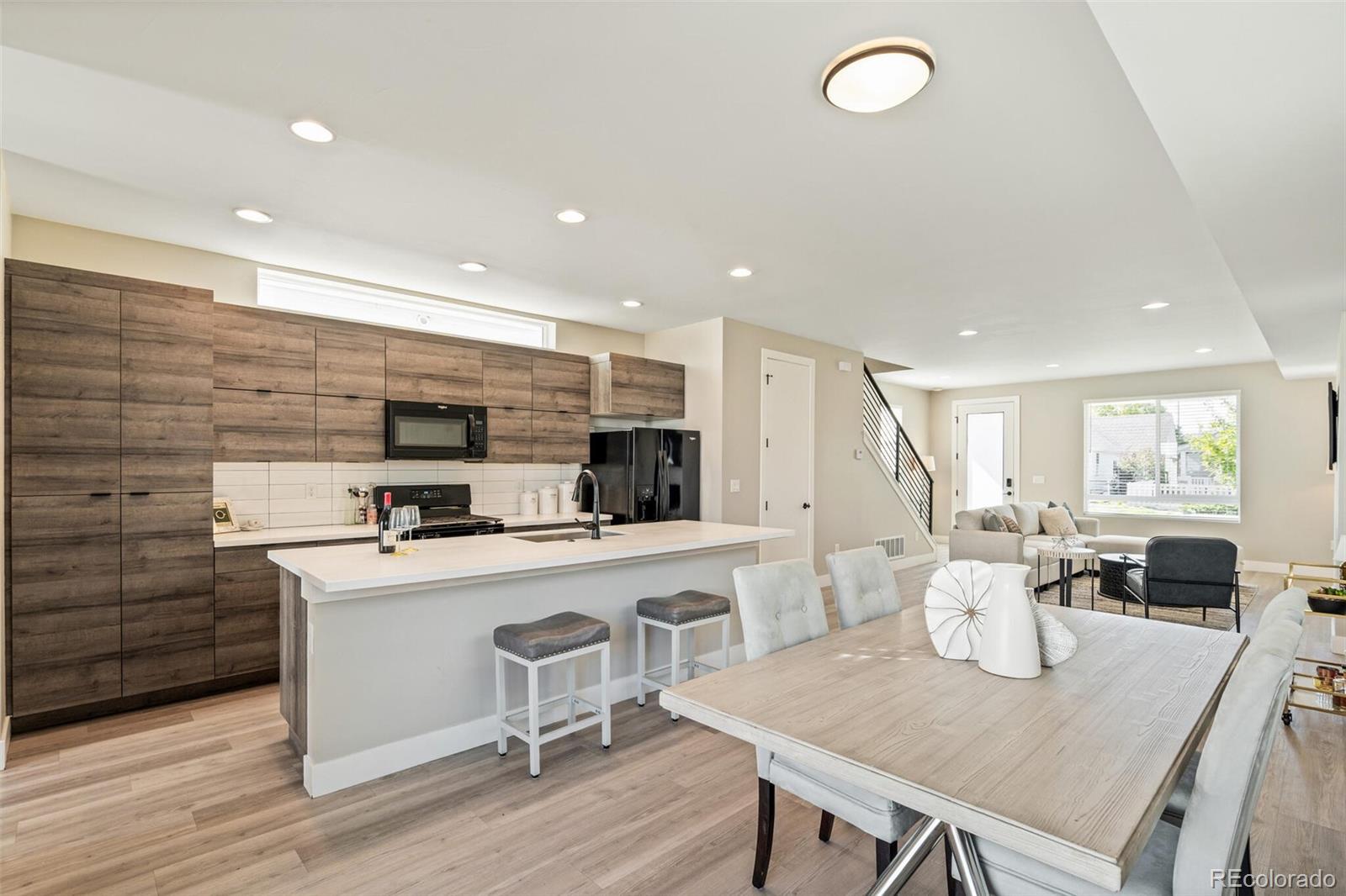4306 Sherman Street Denver, CO 80216 - Photo 11 of 32 a living room with stainless steel appliances furniture a dining table and kitchen view