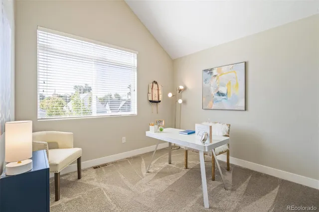a view of a workspace with furniture and a window