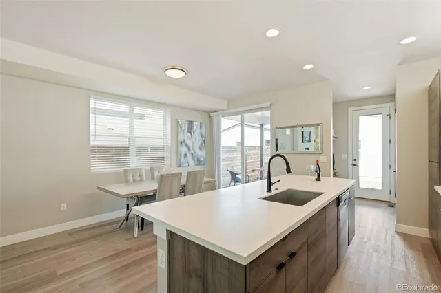 a kitchen with kitchen island a sink and wooden floors