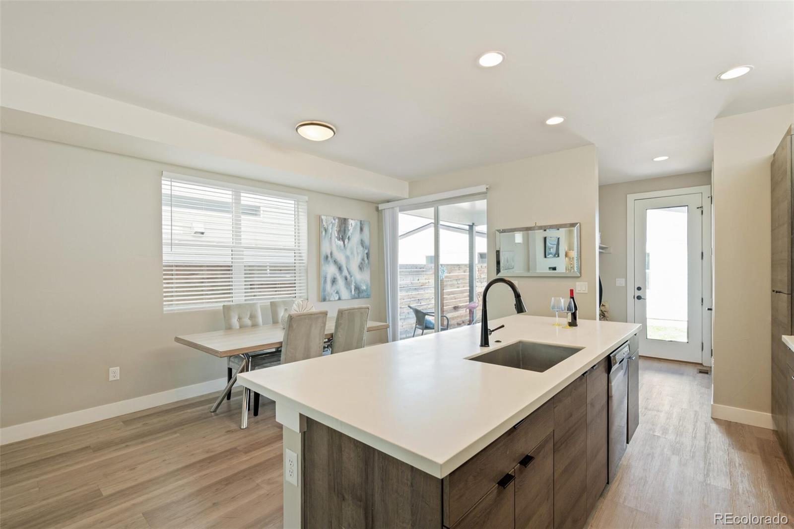 4306 Sherman Street Denver, CO 80216 - Photo 9 of 32 a kitchen with kitchen island a sink and wooden floors