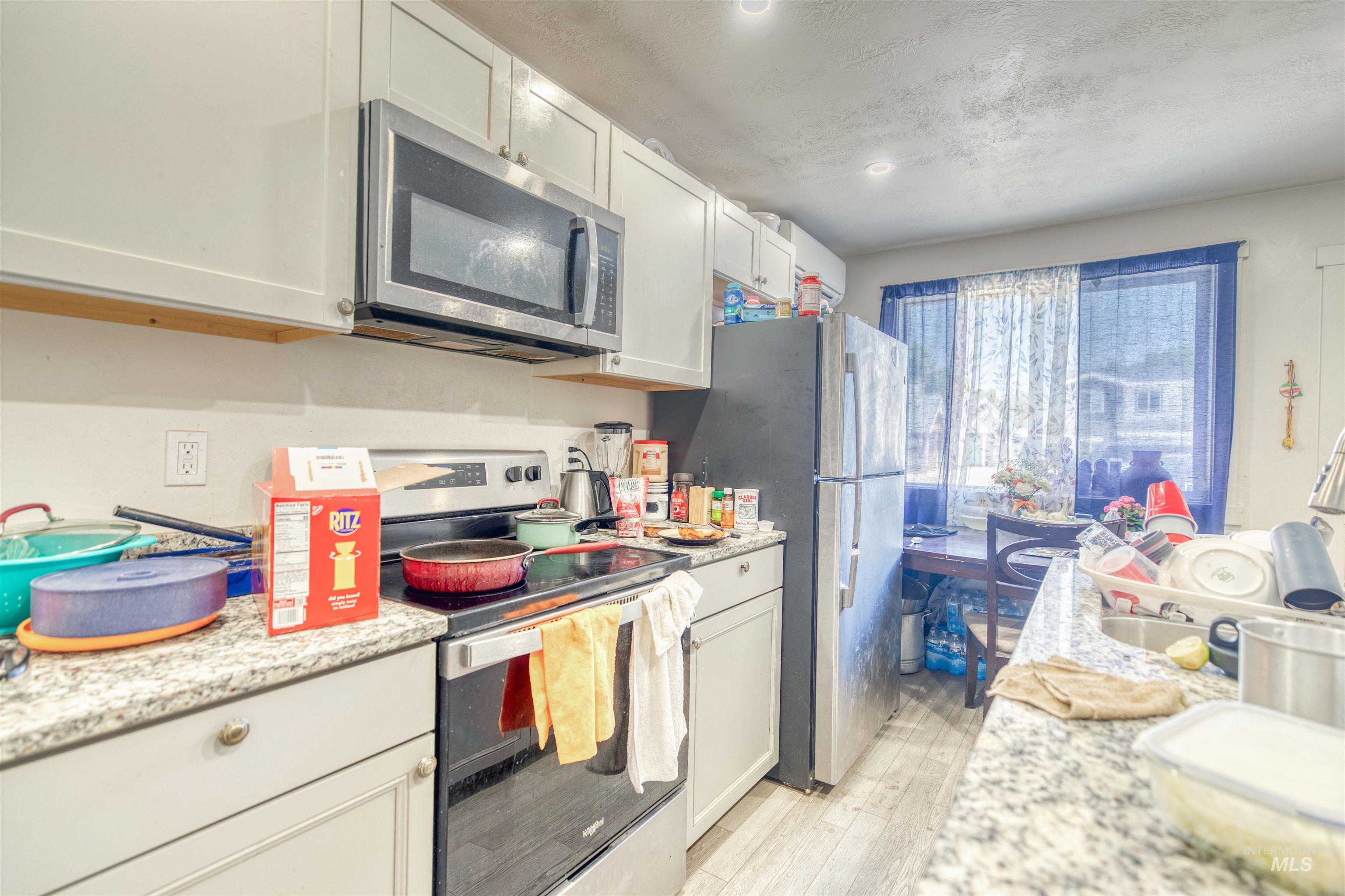 106 East Main Street Nyssa, OR 97913 - Photo 16 of 32 Kitchen featuring stainless steel appliances, light wood-type flooring, and white cabinets