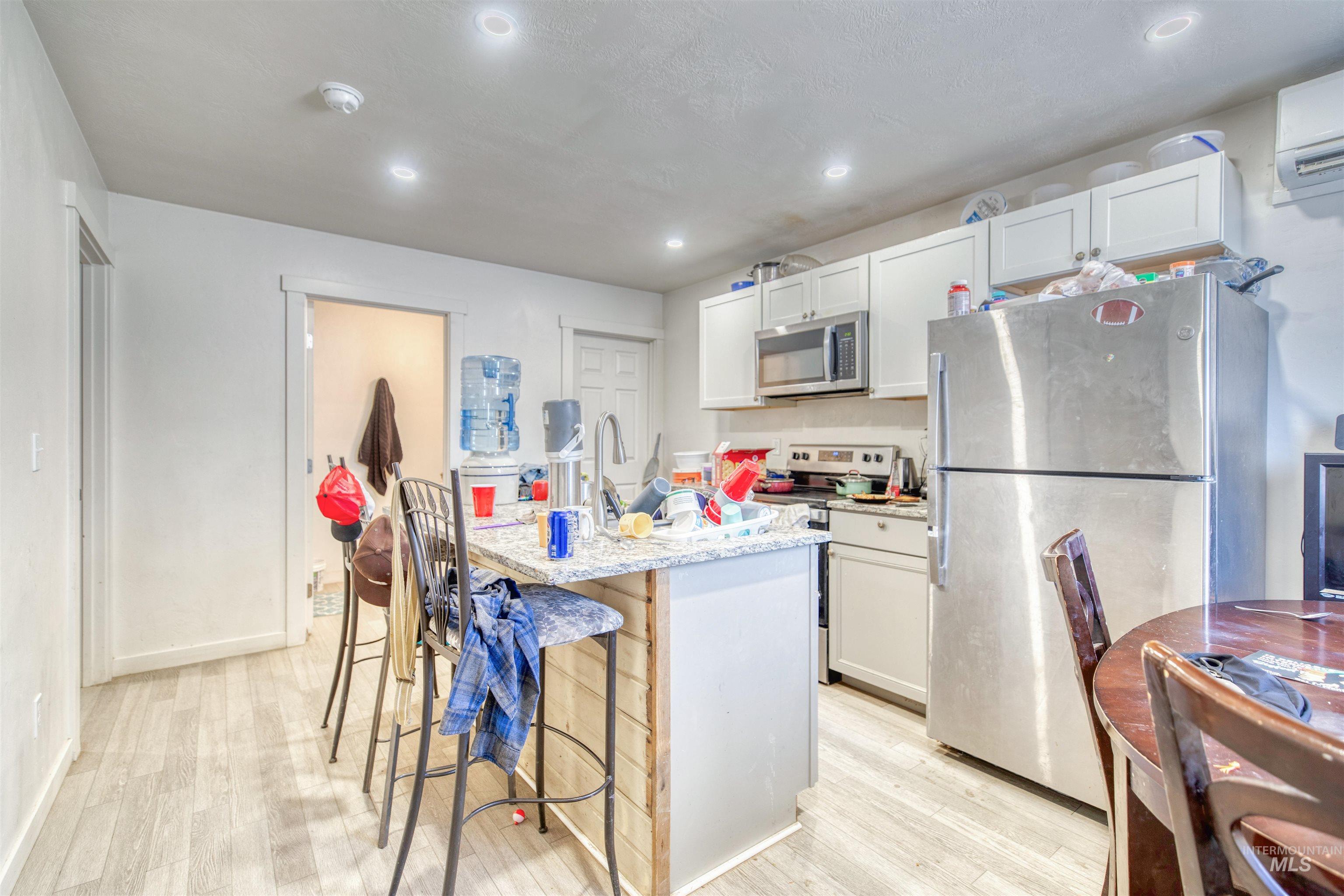 106 East Main Street Nyssa, OR 97913 - Photo 20 of 32 Kitchen with stainless steel appliances, light wood-type flooring, a breakfast bar, a kitchen island with sink, and recessed lighting