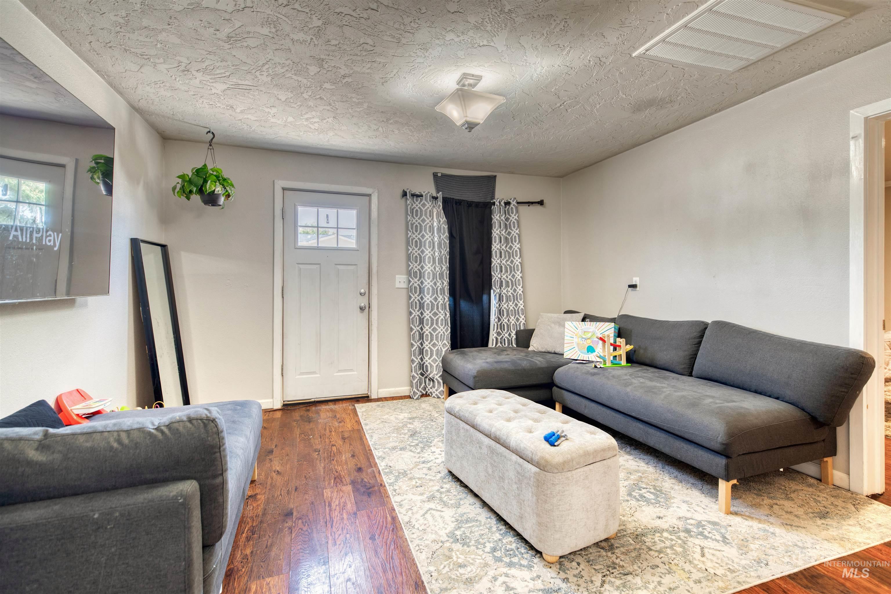 106 East Main Street Nyssa, OR 97913 - Photo 6 of 32 Living room featuring wood-type flooring and a textured ceiling
