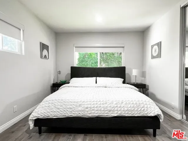 a large bed sitting in a bedroom next to a window
