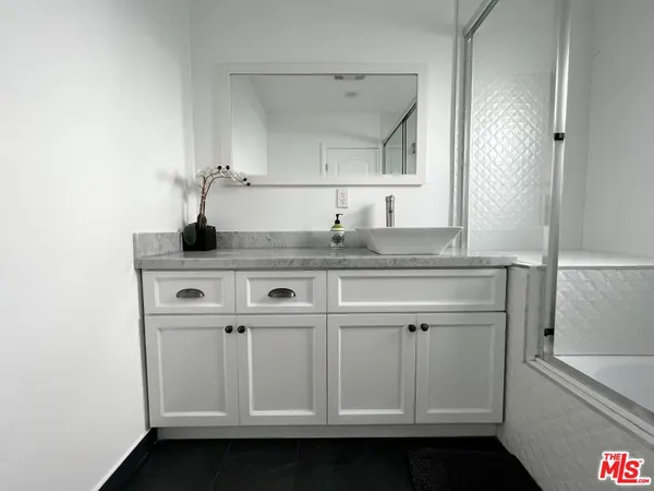 a view of cabinets a sink and a mirror in a room