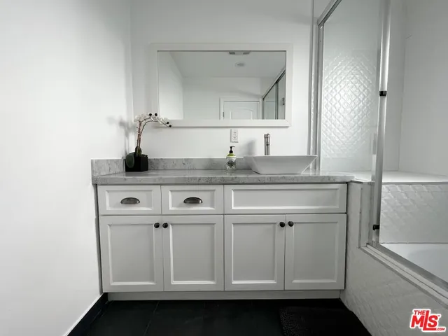 a view of cabinets a sink and a mirror in a room
