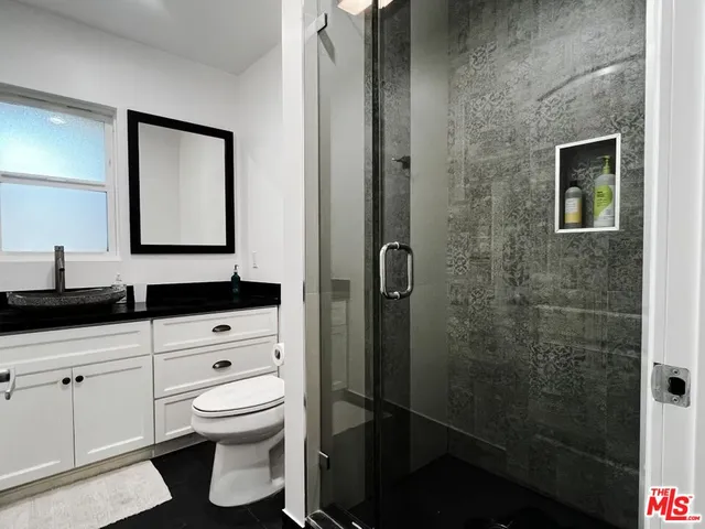 a bathroom with a toilet a sink and mirror