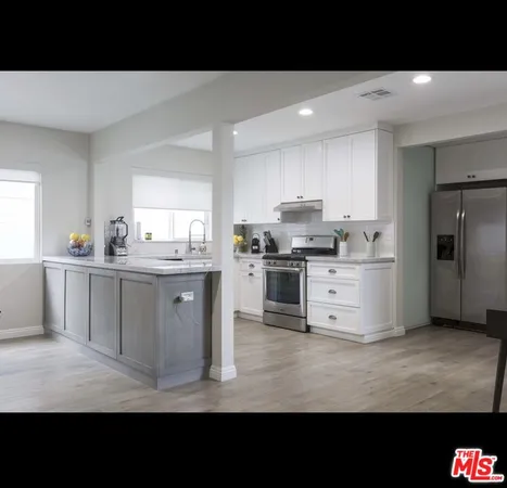 a kitchen with stainless steel appliances kitchen island granite countertop a stove top oven a sink and dishwasher