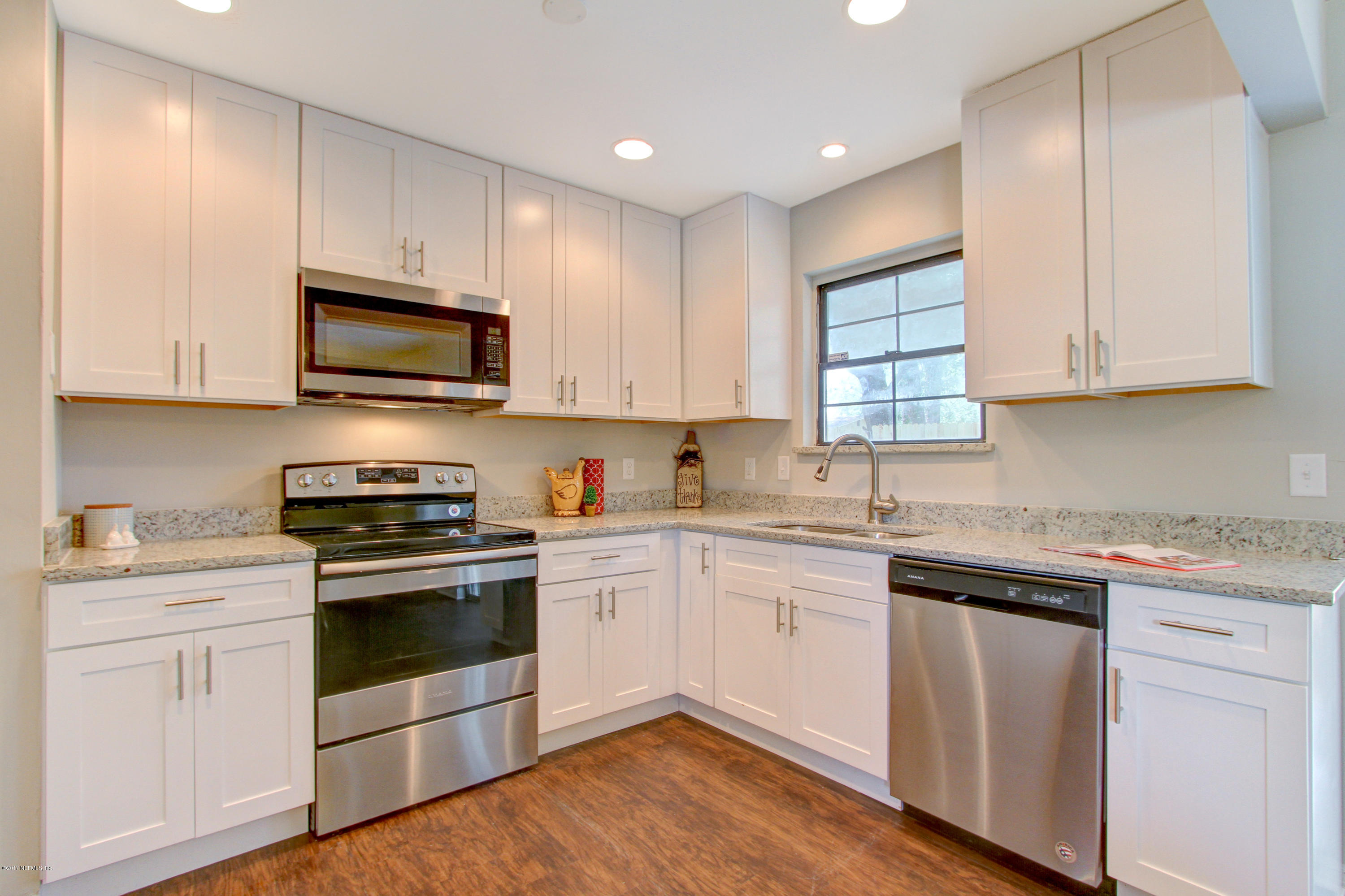 8236 Cassie Road Jacksonville, FL 32221 - Photo 11 of 29 a kitchen with cabinets stainless steel appliances a sink and wooden floor