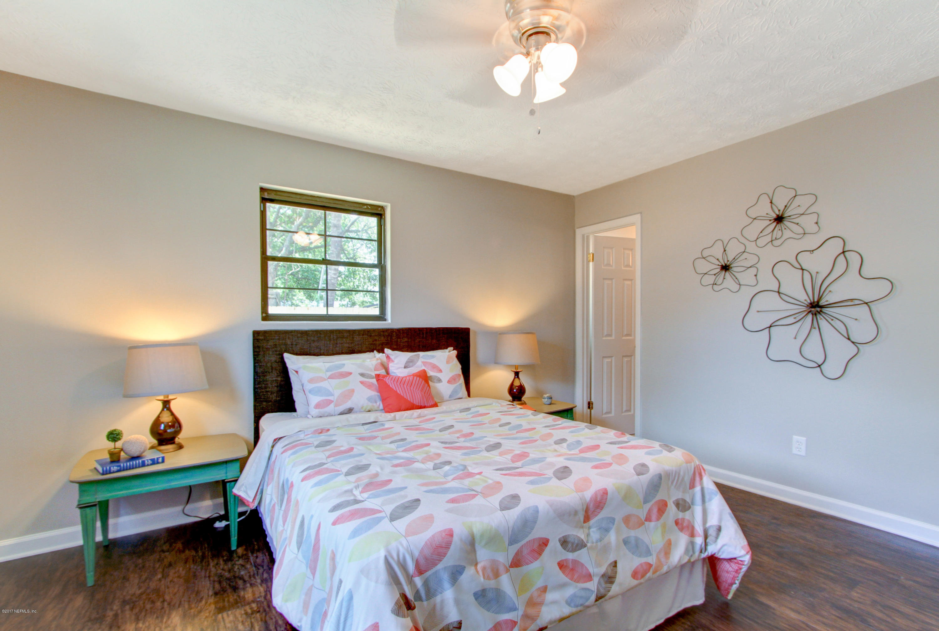 8236 Cassie Road Jacksonville, FL 32221 - Photo 18 of 29 a bedroom with a bed and a chandelier