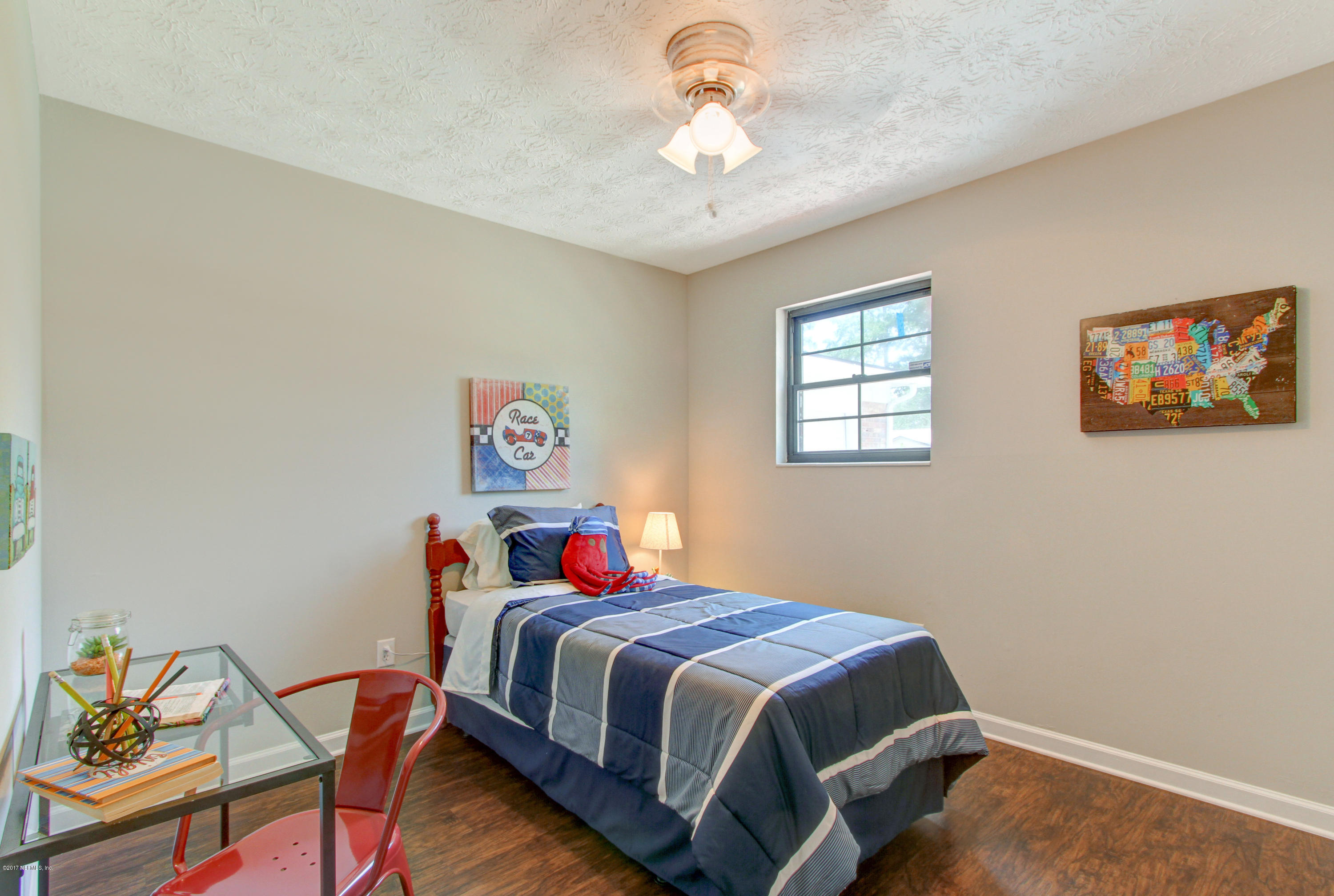 8236 Cassie Road Jacksonville, FL 32221 - Photo 23 of 29 a bedroom with a bed and a chandelier