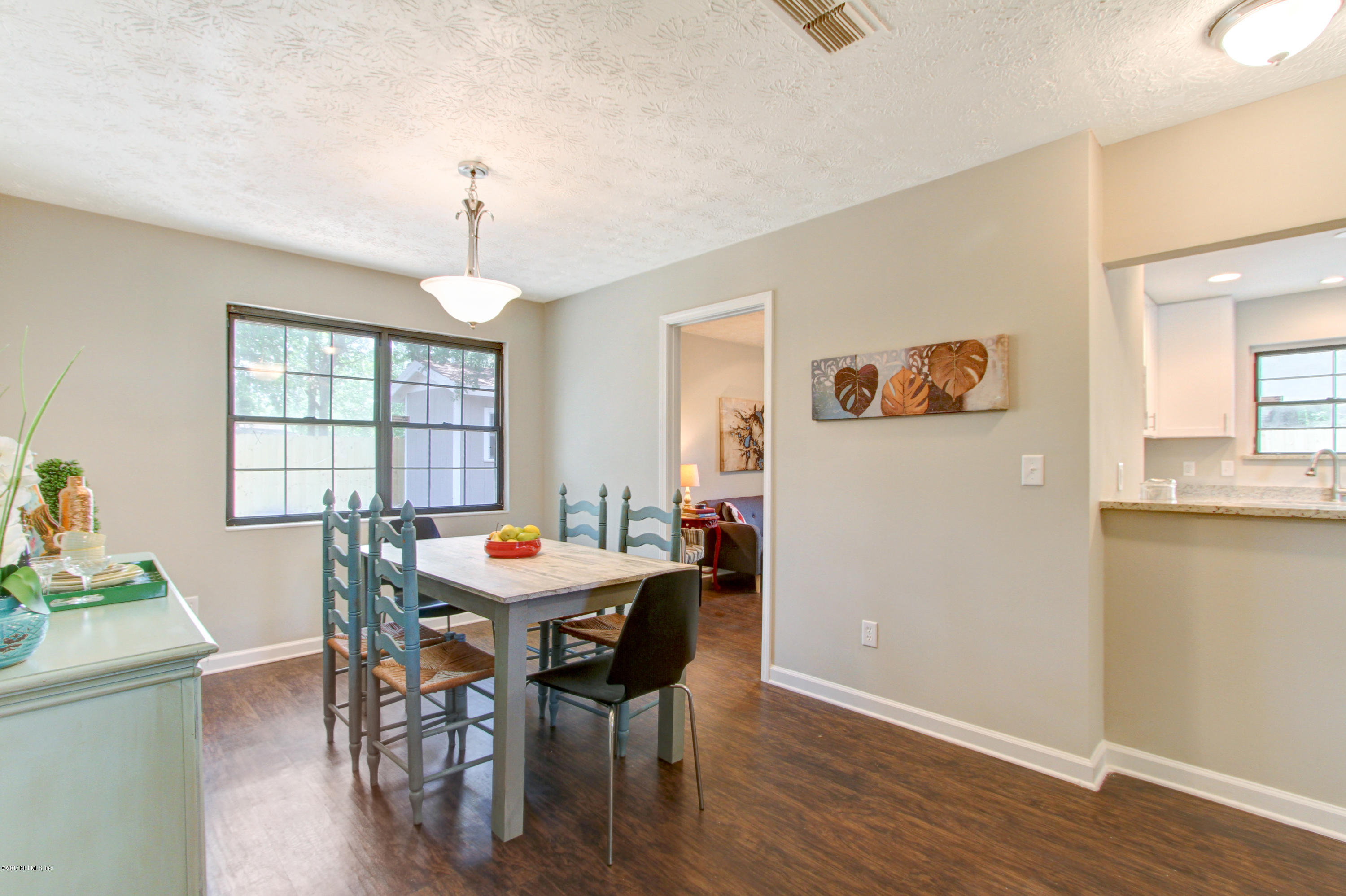 8236 Cassie Road Jacksonville, FL 32221 - Photo 9 of 29 a dining room with furniture a chandelier and wooden floor
