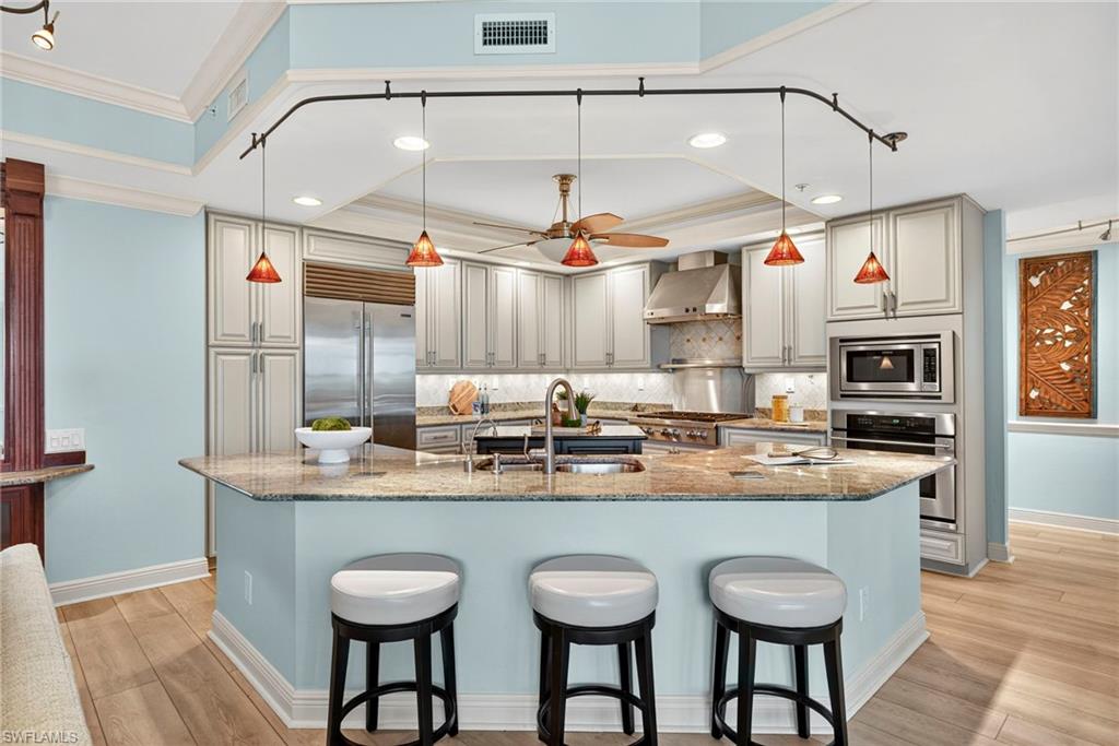 285 Grande Way, Unit 804 Naples, FL 34110 - Photo 11 of 50 a kitchen with stainless steel appliances granite countertop a sink and a refrigerator