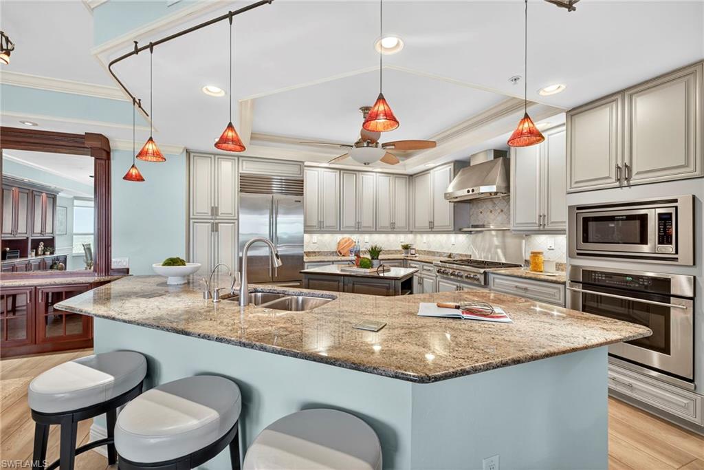 285 Grande Way, Unit 804 Naples, FL 34110 - Photo 12 of 50 a kitchen with stainless steel appliances granite countertop a sink a stove and chairs
