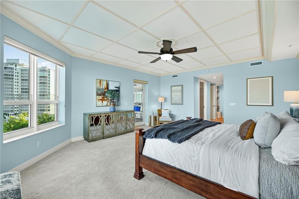 285 Grande Way, Unit 804 Naples, FL 34110 - Photo 28 of 50 a spacious bedroom with a large bed and a chandelier