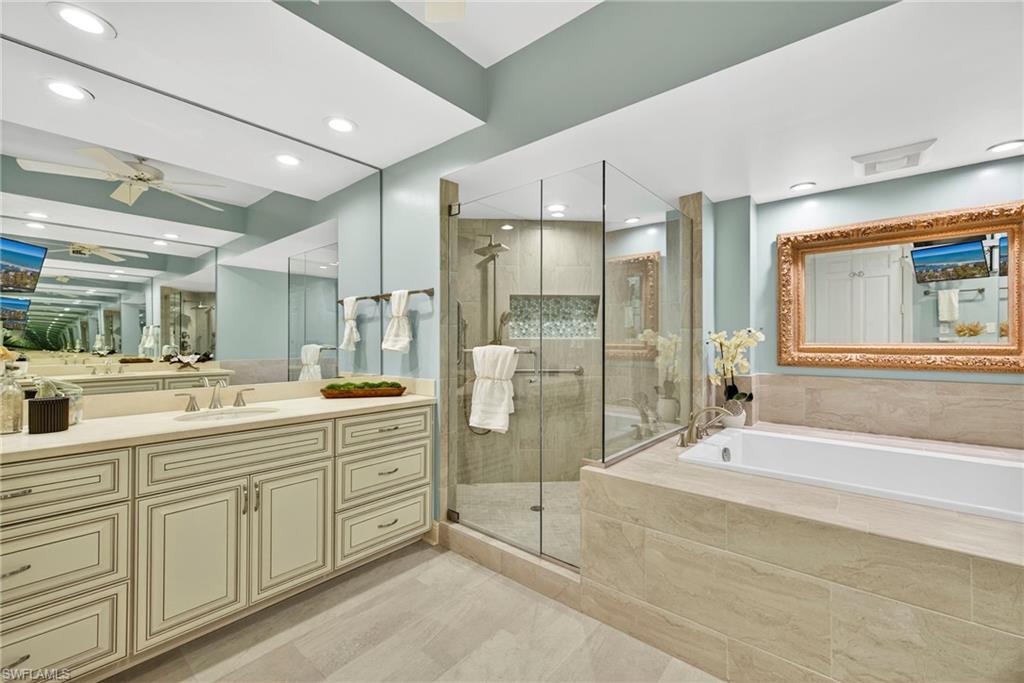 285 Grande Way, Unit 804 Naples, FL 34110 - Photo 29 of 50 a spacious bathroom with a shower sink and mirror