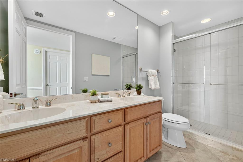 285 Grande Way, Unit 804 Naples, FL 34110 - Photo 32 of 50 a bathroom with a double vanity sink toilet and shower