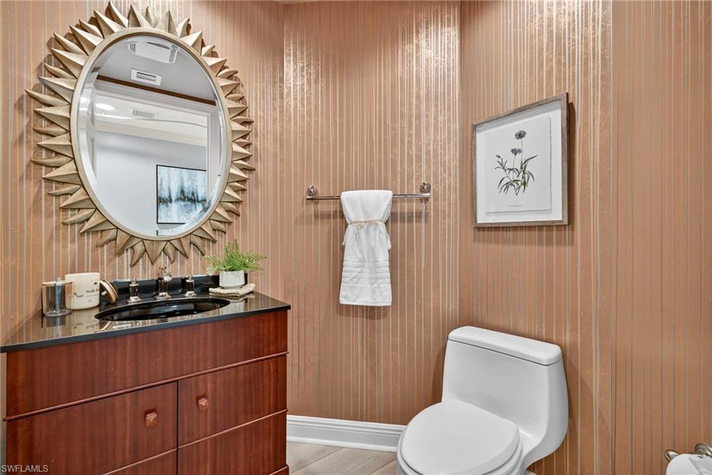 285 Grande Way, Unit 804 Naples, FL 34110 - Photo 33 of 50 a bathroom with a toilet a sink and mirror