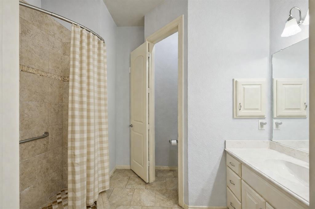 1520 Snider Court Lucas, TX 75002 - Photo 23 of 40 Secondary primary bathroom with tiled walk-in shower, large vanity, water closet, and a bright, well-maintained feel.