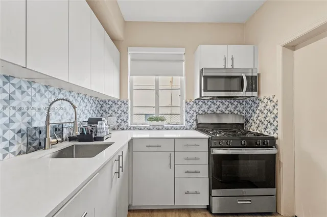 a kitchen with white cabinets and stainless steel appliances