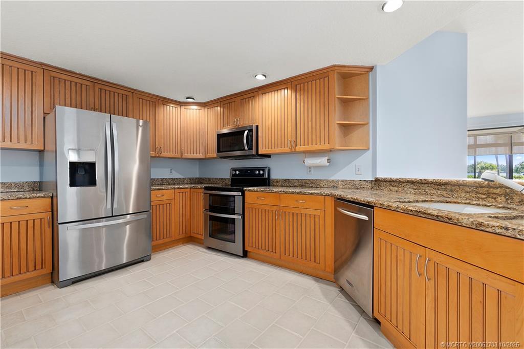 6122 Southeast Landing Way, Unit 4 Stuart, FL 34997 - Photo 20 of 29 a kitchen with granite countertop a refrigerator stove top oven and sink