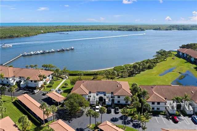 an aerial view of a house with a garden and lake view