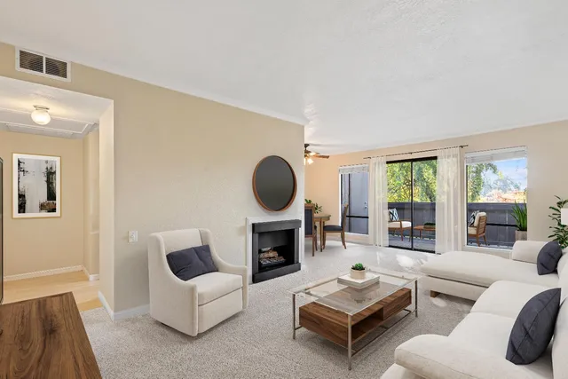 a living room with furniture fireplace and a large window