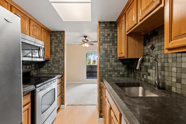a kitchen with granite countertop a sink and a stove top oven