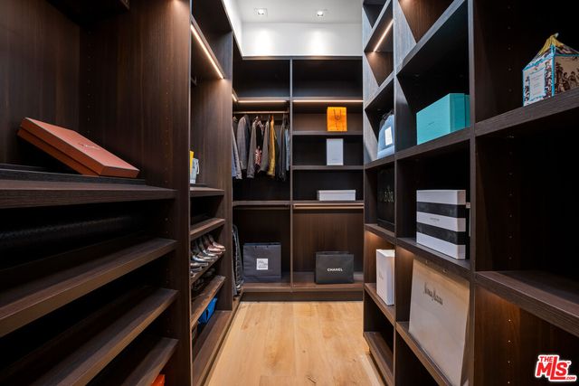 a view of walk in closet with wooden floor