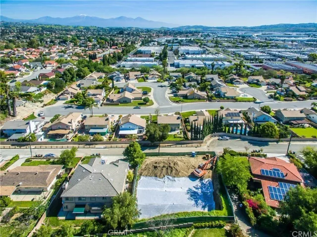 an aerial view of residential houses with outdoor space and trees