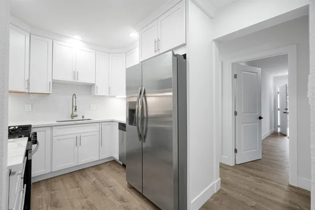 a kitchen with a refrigerator sink and cabinets