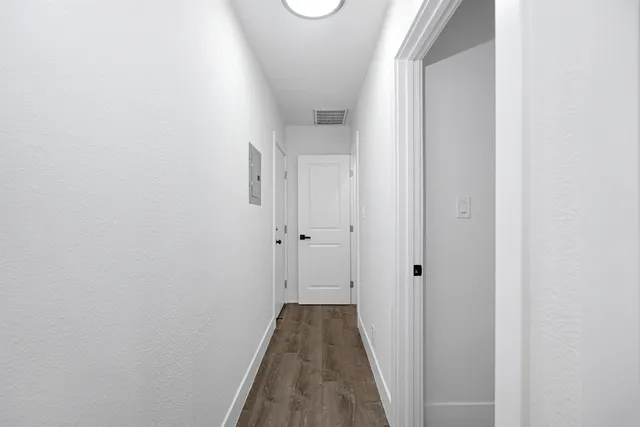 a view of a hallway with wooden floor and closet
