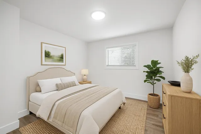 a bedroom with bed and a potted plant