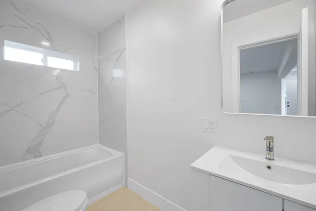 a bathroom with a bath tub a sink and a mirror