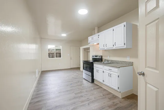 a kitchen with granite countertop white cabinets and white appliances