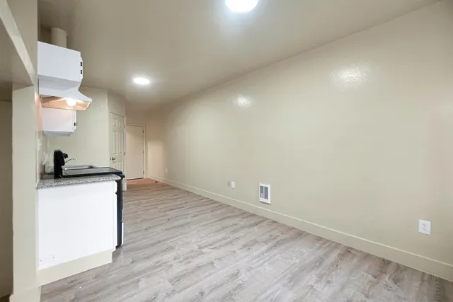 a view of empty room with wooden floor