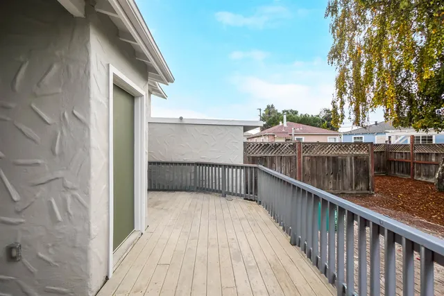 a balcony with wooden floor and fence
