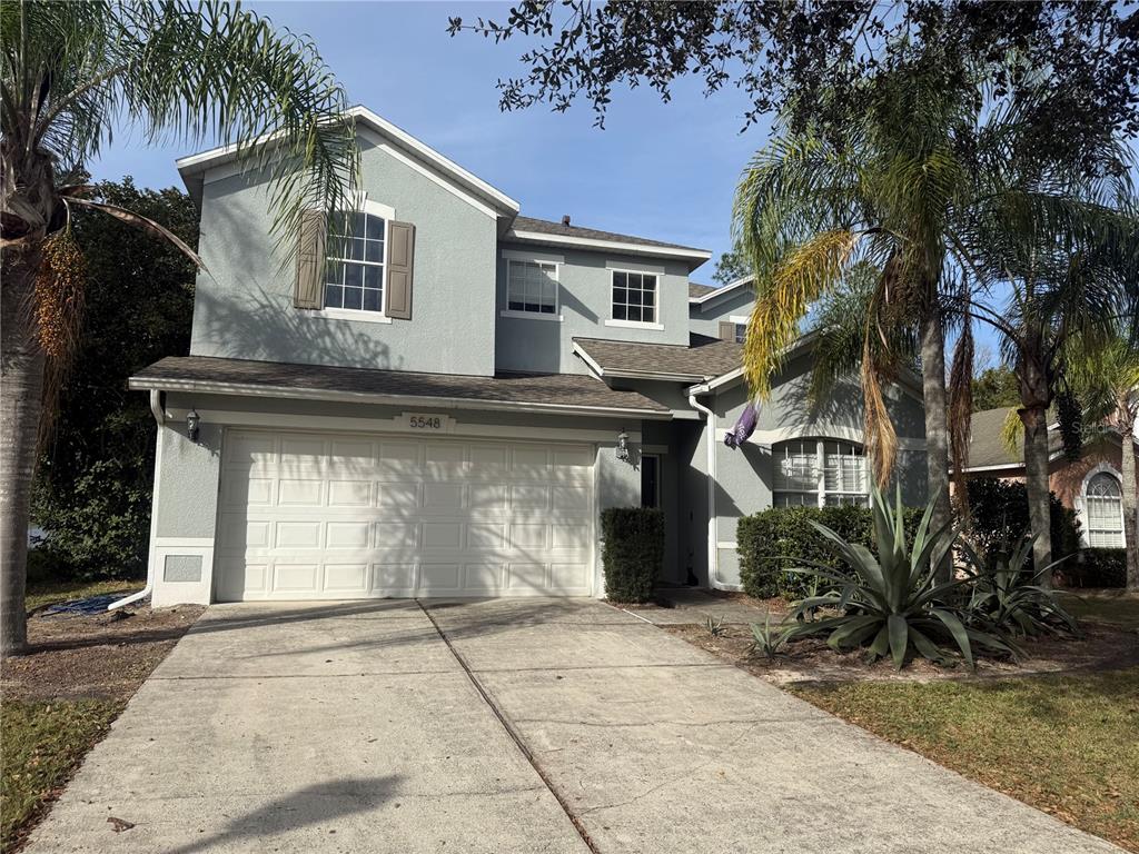 a view of a white house with a large tree